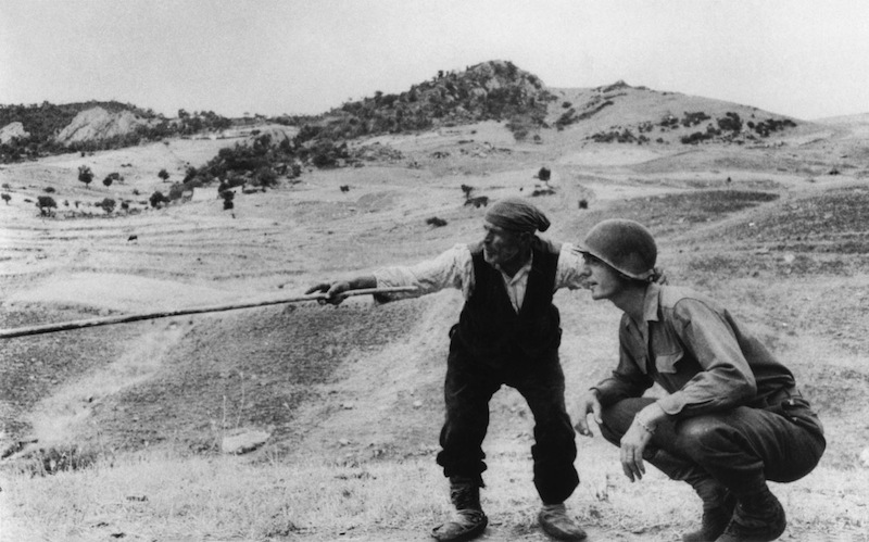 Contadino siciliano che parla con un ufficiale americano indicando un convoglio tedesco, nei pressi di Troina, Sicilia, 4-5 Agosto 1943, © Robert Capa/ International Center of Photography/ Magnum Phot