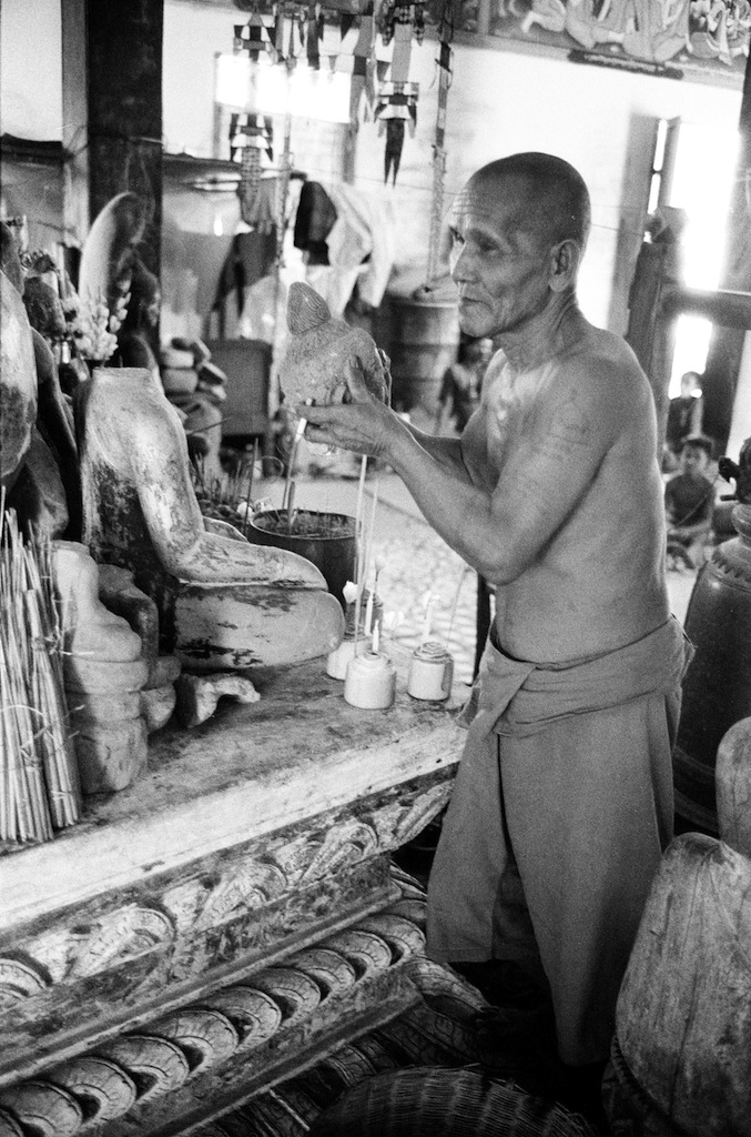 Monaco che mostra la testa tagliata di un Buddha (loc. Angkor?), 1980 © Archivio Terzani