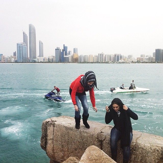 2014-04-16_Young women climb over rocks at the Breakwater Corniche in Abu Dhabi, a popular spot for skyline and jet-skiers watching _ ph Silvia Razgova