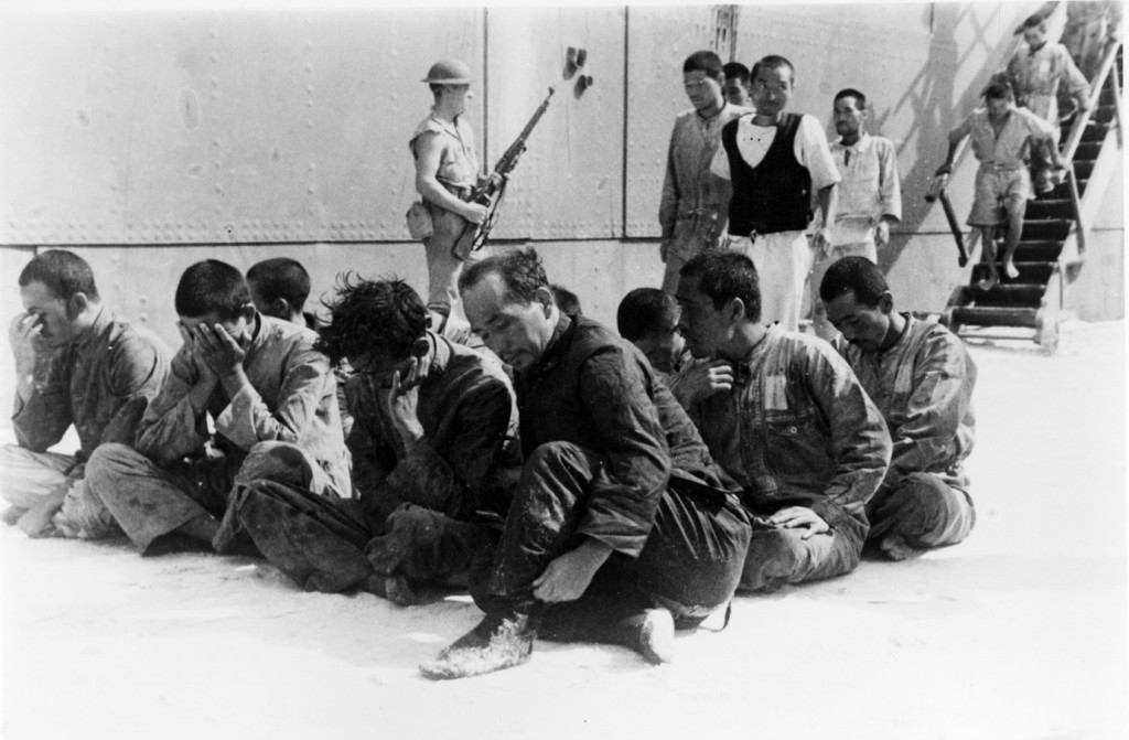 “Prigionieri di Guerra giapponesi guardati a vista da soldati americani, dopo essere stati recuperati da una scialuppa di salvataggio dalla USS Ballard (AVD-10) nel giugno 1942. Sono i sopravvissuti della portaerei affondata Hiryu. Dopo essere stati trattenuti per alcuni giorni a Midway, sono stati mandati a Pearl Harbor il 23 giugno a bordo della USS Sirius (AK-15), arrivando il primo luglio. Da notare il marine di guardia al centro dietro il gruppo di prigionieri armato con un fucile M1903 Springfield”. Autore sconosciuto, Foto ufficiale della U.S. Navy ora nelle collezioni dei National Archives, courtesy U.S. National Archives Per la Marina Imperiale la battaglia delle Midway terminava disastrosamente, con la grave perdita di quattro grandi portaerei di squadra (orgoglio del Giappone), di un moderno incrociatore pesante e di centinaia di marinai e aviatori esperti e addestrati. Le perdite aeree ammontarono a oltre 300 velivoli, tra cui tutti quelli presenti sulle portaerei affondate e altri 33 caccia stivati nei depositi delle navi, in vista di un loro impiego a Midway dopo l’eventuale occupazione delle isole. Anche le perdite aeree americane furono tuttavia pesanti: 147 velivoli abbattuti, la Yorktown venne affondata, riducendo (dopo la perdita della Lexington) a tre le portaerei americane ancora operative. La clamorosa vittoria però mutava completamente il quadro strategico generale delle guerra del Pacifico. 