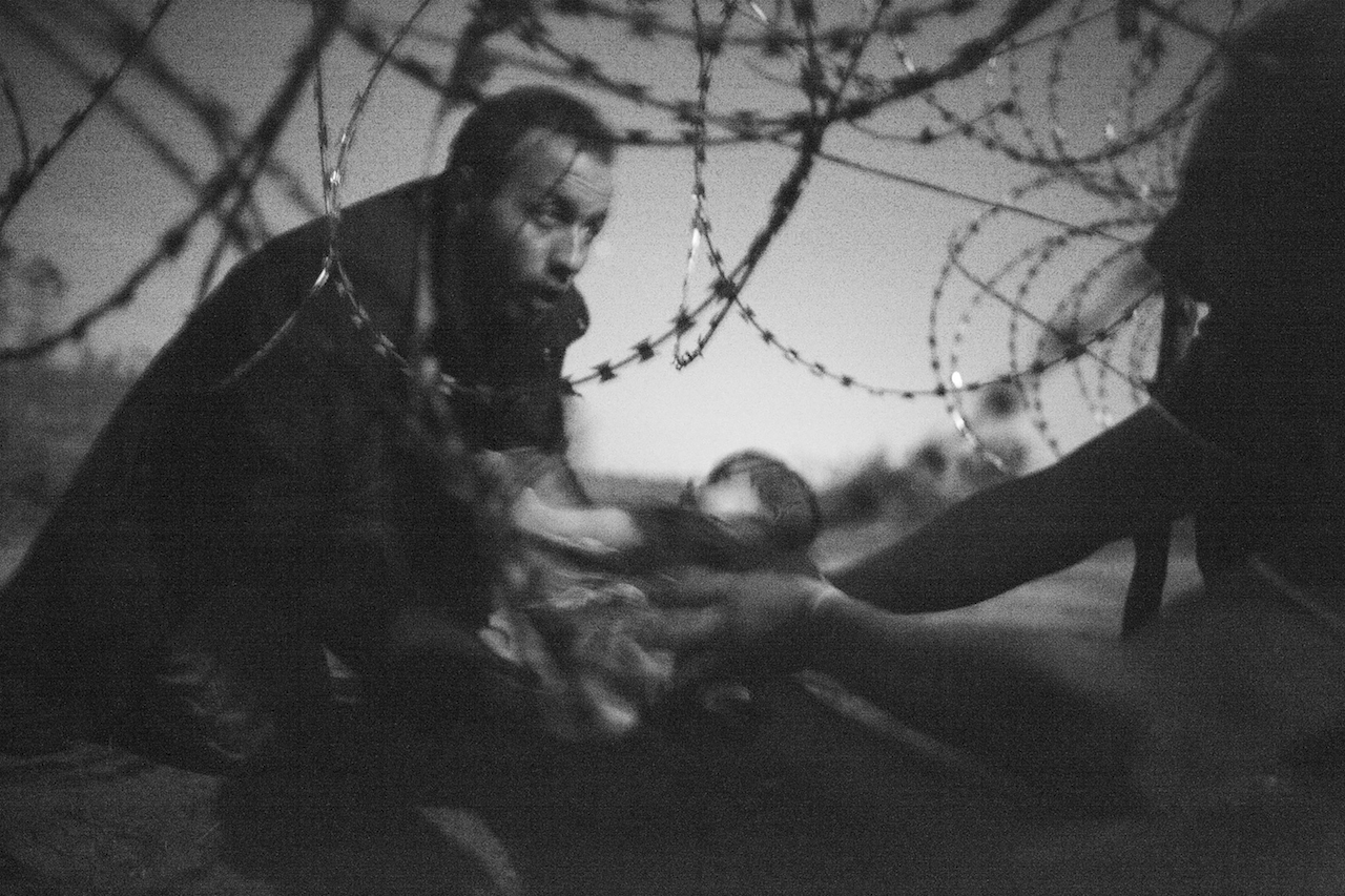 Premio World Press - Foto dell’anno Warren Richardson, Australia, 2015 Speranza per una nuova vita Un uomo aiuta a passare un neonato attraverso il filo spinato di un cancello al confine tra Serbia e Ungheria, nella città di Roskzke, in Ungheria, il 28 agosto 2015.