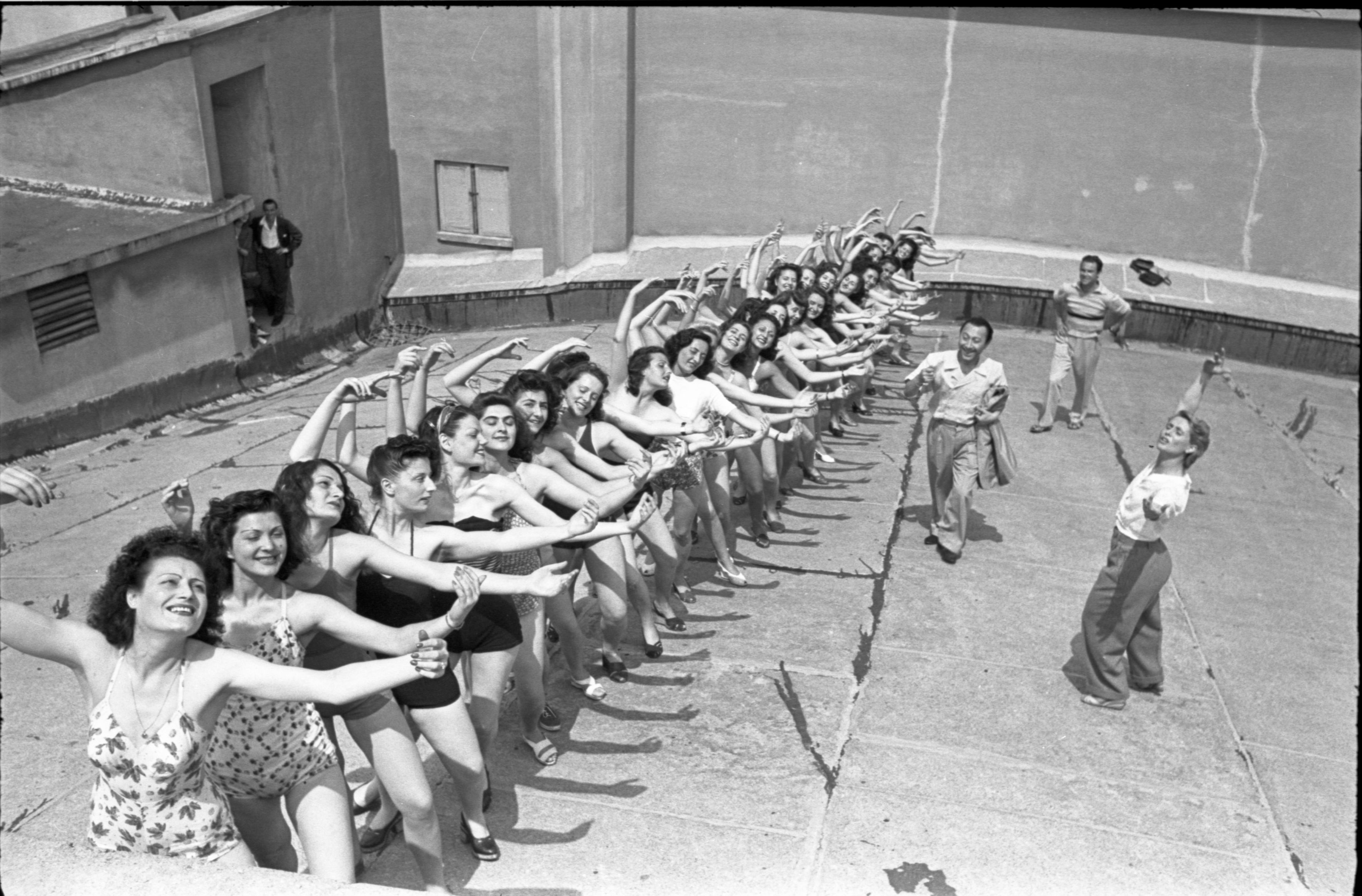 Federico Patellani, Italia Dopoguerra. Le ballerine del corpo di ballo Macario in fila sul tetto del Teatro Lirico, Milano, 1946