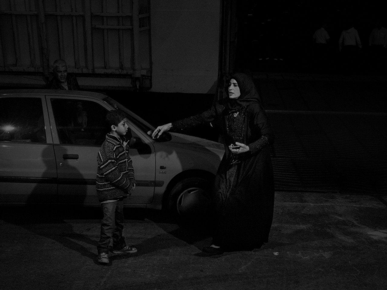 Greece. 2015. A syrian refugee woman desperately searching for her two year old child which she lost on the journey to Pireus from Lesbos. While I was photographing the refugees coming into the port, I noticed this woman who was desperately searching for her lost child and was surprised to see her leave without having found her. She was faced with a hard decision: choosing to leave a child behind and carry on her journey for her other children’s sake or lose the bus that would take her to the next checkpoint of her journey.