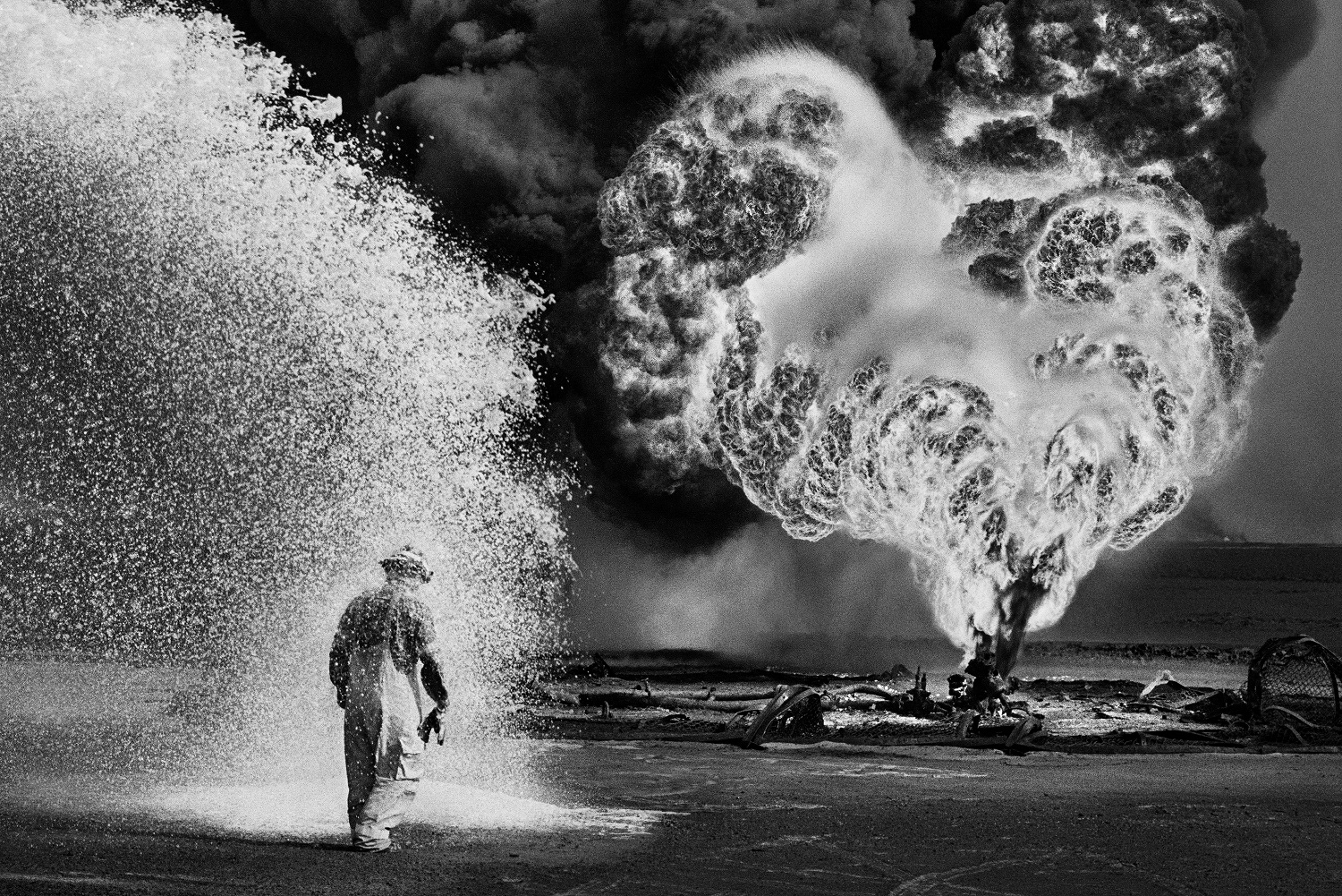 Spray chimici proteggono questo pompiere dal calore delle fiamme. Pozzi di petrolio, Greater Burhan, Kuwait, 1991. © Sebastião Salgado /Amazonas Images/Contrasto