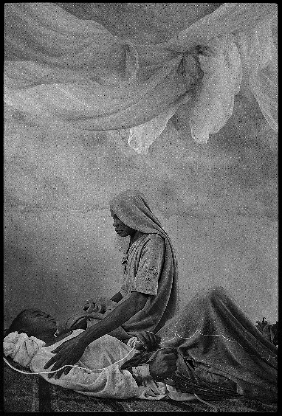 James Nachtwey, Una madre accudisce il figlio malato di epatite E in un ospedale nel Darfur, 2004 © James Nachtwey