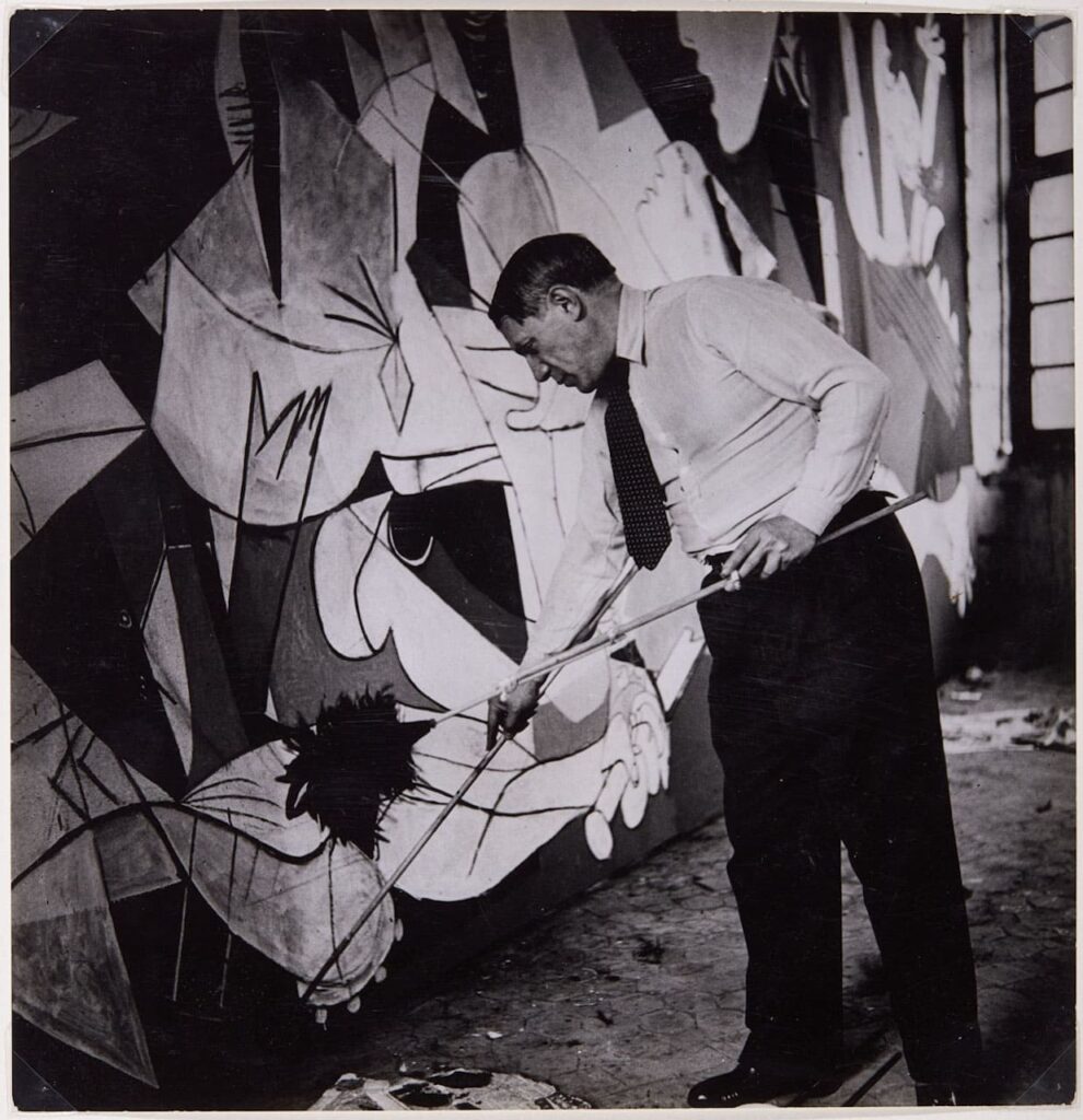 Dora Maar, Picasso de pié trabajando en el Guernica en su taller de los Grands-Augustins, 1937 © Dora Maar © Succession Picasso by SIAE 2022. Questa immagine può essere utilizzata solo a corredo di brevi articoli o segnalazioni a fini di cronaca.