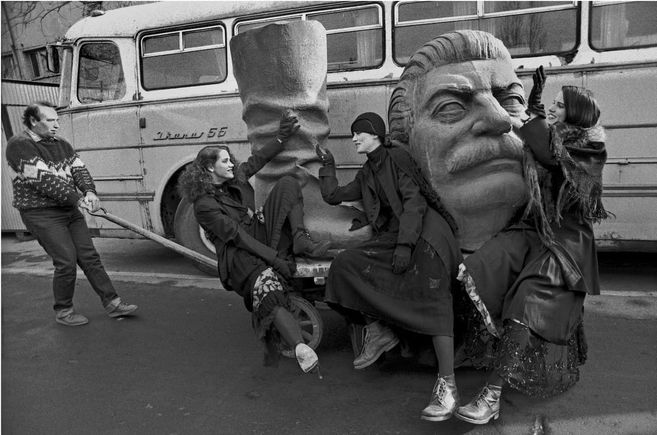 Ferdinando Scianna, Budapest, Ungheria, 1990. Tre allegre ragazze accompagnano Josip Stalin alla pattumiera della storia, 1990, 43x49 cm © Ferdinando Scianna