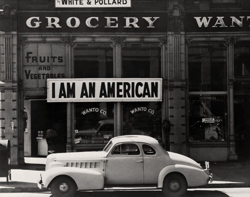 Dorothea Lange A large sign reading “I am an American” placed in the window of a store the day after Pearl Harbor. Oakland, California, 1942 The New York Public Library | Library of Congress Prints and Photographs Division Washington